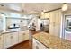 Open-concept kitchen with hardwood floors, granite counters, and stainless steel appliances adjacent to the living room at 2525 S Pennsylvania St, Denver, CO 80210