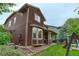 View of the home's exterior with a cozy covered patio and lush backyard featuring a playset and mature trees at 24686 E Florida Ave, Aurora, CO 80018