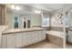 Bright bathroom featuring a double sink vanity, soaking tub, and tiled accents, offering a spa-like experience at 24686 E Florida Ave, Aurora, CO 80018