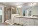 Primary bathroom features double sinks, a glass enclosed shower, and neutral tile at 24686 E Florida Ave, Aurora, CO 80018
