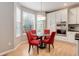 Kitchen breakfast nook featuring a round glass table, bright red chairs, and natural light at 24686 E Florida Ave, Aurora, CO 80018