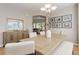 Light and airy dining room featuring a large wooden table with seating for six, a chandelier, and a buffet at 24686 E Florida Ave, Aurora, CO 80018