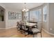 Bright dining room featuring a wooden table, six chairs, a chandelier, and natural light from windows with blinds at 24686 E Florida Ave, Aurora, CO 80018