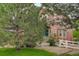 Exterior of the home shows the front yard with mature tree and partial white picket fence at 24686 E Florida Ave, Aurora, CO 80018
