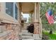 Covered front porch featuring stone pillars and an American flag at 24686 E Florida Ave, Aurora, CO 80018