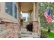 Inviting front porch with stone pillars and outdoor seating, showcasing American flag at 24686 E Florida Ave, Aurora, CO 80018