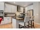 Modern kitchen features white cabinetry, stainless steel appliances, and a black countertop island with seating at 24686 E Florida Ave, Aurora, CO 80018