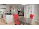 Modern kitchen features stainless steel appliances, black countertop, and breakfast nook with red chairs at 24686 E Florida Ave, Aurora, CO 80018