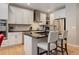 Modern kitchen features white cabinets, stainless steel appliances, and a black countertop island with seating at 24686 E Florida Ave, Aurora, CO 80018