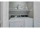Convenient laundry area with washer, dryer, and storage shelving at 24686 E Florida Ave, Aurora, CO 80018