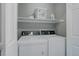 Laundry room featuring a white washer and dryer unit with a shelf overhead at 24686 E Florida Ave, Aurora, CO 80018