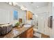 Well-lit bathroom with granite countertop and tiled shower at 6390 S Xanadu St, Englewood, CO 80111