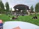Outdoor venue with a stage, green lawn seating, and many people enjoying the event at 6390 S Xanadu St, Englewood, CO 80111