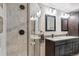 Bathroom with a glass shower, dark cabinets, mosaic tile backsplash, and double vanity at 19739 E Wagontrail Dr, Centennial, CO 80015