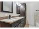 Bathroom with granite counters, dark cabinets, and double vanity at 19739 E Wagontrail Dr, Centennial, CO 80015