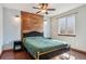 Stylish bedroom featuring a wood accent wall, hardwood floors, and a modern ceiling fan at 19739 E Wagontrail Dr, Centennial, CO 80015