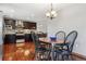 Kitchen and dining area with hardwood floors, dark cabinets, stainless steel appliances, and pendant lighting at 19739 E Wagontrail Dr, Centennial, CO 80015