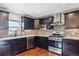 Contemporary kitchen with stainless steel appliances, dark cabinets, tile backsplash, and hardwood floors at 19739 E Wagontrail Dr, Centennial, CO 80015