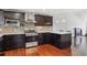 Well-lit kitchen featuring stainless steel appliances, dark cabinets, tile backsplash, and hardwood floors at 19739 E Wagontrail Dr, Centennial, CO 80015