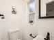 Bathroom featuring a white toilet, and window with a flower pot at 5951 Oneida St, Commerce City, CO 80022