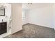 Bedroom with adjacent bathroom, bright window, and neutral carpeting at 5951 Oneida St, Commerce City, CO 80022