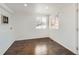 Sunlit bedroom with hardwood floors, white walls, and large windows at 5951 Oneida St, Commerce City, CO 80022