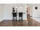 Bright kitchen with a breakfast bar featuring pendant lighting and dark wood floors at 5951 Oneida St, Commerce City, CO 80022