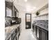 Well-lit kitchen featuring granite countertops, dark cabinetry, and stainless steel appliances at 5951 Oneida St, Commerce City, CO 80022