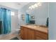 Bright bathroom features single sink vanity, toilet and tub with shower and teal shower curtain at 11615 E Maplewood Ave, Englewood, CO 80111