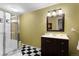 Bright bathroom featuring a glass shower enclosure, checkered floors and a modern vanity at 11615 E Maplewood Ave, Englewood, CO 80111