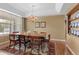 Bright dining room with a large window, chandelier, and formal dining set at 11615 E Maplewood Ave, Englewood, CO 80111