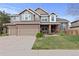 Charming two-story home with a well-manicured lawn and attached two car garage at 11615 E Maplewood Ave, Englewood, CO 80111