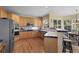 Eat-in kitchen has stainless steel appliances, wood cabinets, blue tile counters, and a breakfast bar with seating for three at 11615 E Maplewood Ave, Englewood, CO 80111