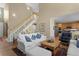 Open-concept living room with high ceilings, hardwood floors, and a staircase at 11615 E Maplewood Ave, Englewood, CO 80111