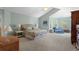 Spacious main bedroom featuring a vaulted ceiling, sitting area, two side tables and lamps, and large windows at 11615 E Maplewood Ave, Englewood, CO 80111