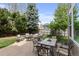 Private backyard patio with mature trees, comfortable seating, and outdoor dining area at 11615 E Maplewood Ave, Englewood, CO 80111