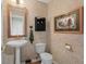 Charming powder room featuring a pedestal sink, a toilet, and decorative wall accents, adding a touch of elegance at 11615 E Maplewood Ave, Englewood, CO 80111