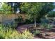 Landscaped garden with a wooden bench and curved path at 56 Hillside Dr, Wheat Ridge, CO 80215