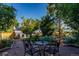 Stone patio with small table and chairs, surrounded by garden at 56 Hillside Dr, Wheat Ridge, CO 80215