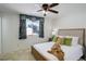 Bedroom showcasing a window with floral valance, a ceiling fan, and a comfortable bed with decorative pillows at 11644 Jackson St, Thornton, CO 80233