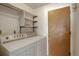 Laundry room showcasing a stacked washer and dryer, shelving for storage, and a door leading to another area at 11644 Jackson St, Thornton, CO 80233