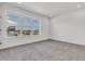 Well-lit bedroom featuring a large window with neighborhood views and neutral carpet at 2108 Alcott Way, Broomfield, CO 80023