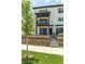 Modern two-story townhome featuring a balcony, gray garage door, and well-manicured landscaping at 2108 Alcott Way, Broomfield, CO 80023