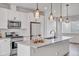 Bright kitchen features white cabinets, stainless steel appliances and pendant lighting over the island at 2108 Alcott Way, Broomfield, CO 80023