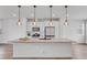 Open kitchen showcases a large island with sink, modern lighting, and stainless steel appliances at 2108 Alcott Way, Broomfield, CO 80023