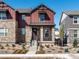 Two-story home with stone and red siding, welcoming front porch, and landscaping at 8115 Mt Harvard Rd, Littleton, CO 80125