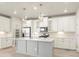 Modern kitchen with white cabinets, gray island, and stainless appliances at 8115 Mt Harvard Rd, Littleton, CO 80125