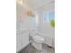 Updated bathroom with white tiling, unique floor tile, and natural light at 3011 Oneida St, Denver, CO 80207