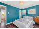 A cozy bedroom featuring hardwood floors, bright blue walls, and a queen bed at 3011 Oneida St, Denver, CO 80207