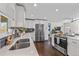 Open kitchen with stainless steel appliances, dark wood floors, and natural light at 3011 Oneida St, Denver, CO 80207